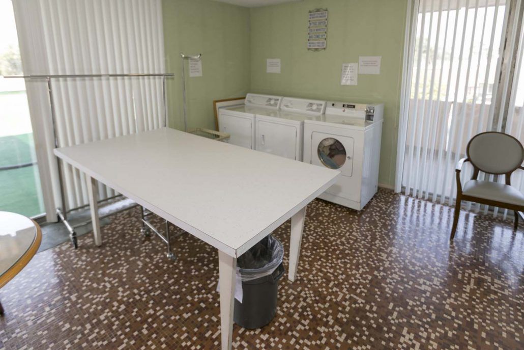 A laundry room with washing machines and a folding table.