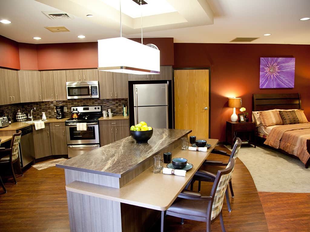 A modern kitchen with an open-concept design, featuring sleek appliances and a dining area.
