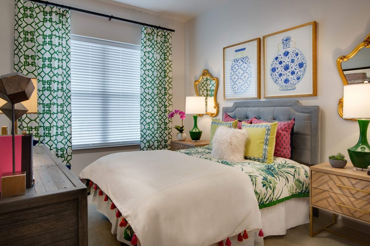 A cozy bedroom with colorful decor and patterned curtains.