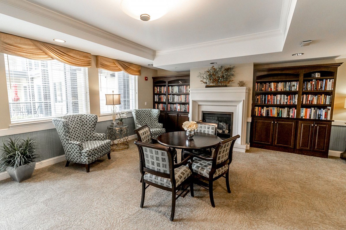 A cozy living room with bookshelves, a fireplace, and comfortable seating.