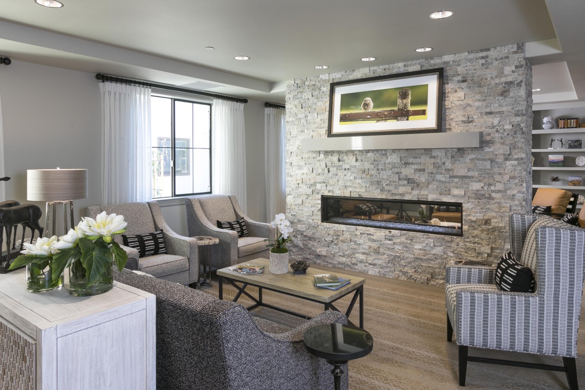 A modern living room with a stone fireplace and stylish furnishings.