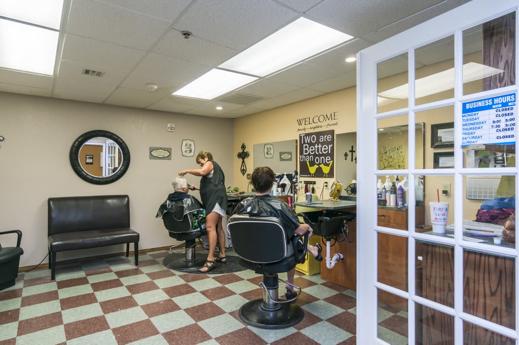 A barbershop interior with customers getting haircuts.
