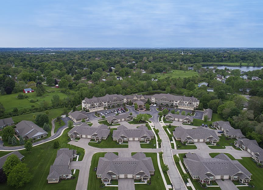 Aerial view of a suburban residential neighborhood surrounded by greenery.