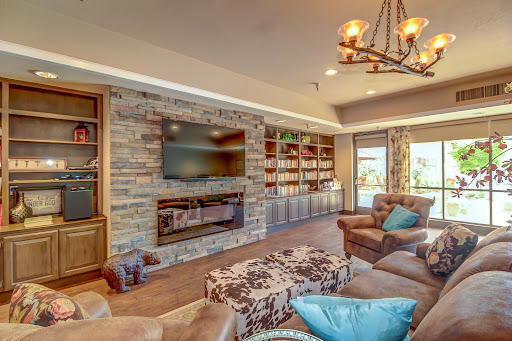 A cozy and modern living room featuring a stylish stone fireplace, built-in bookshelves, and comfortable seating.