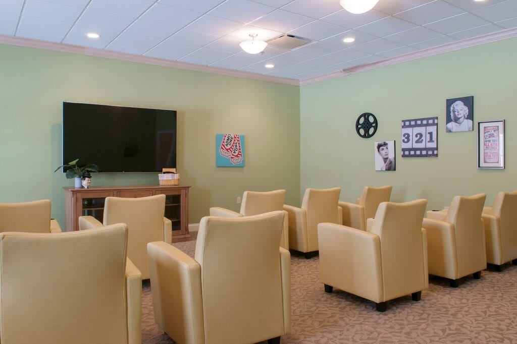 A cozy lounge area with comfortable chairs facing a large television.