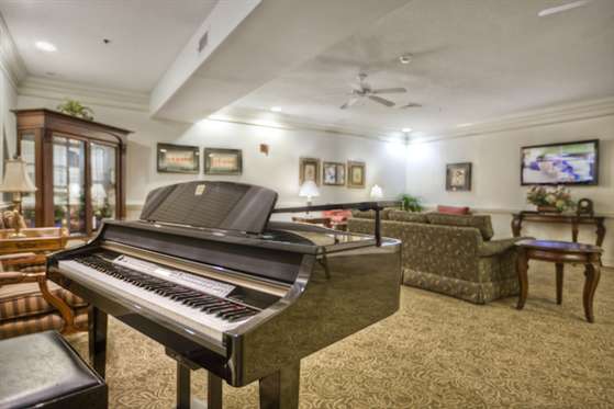 A cozy living room featuring a piano and comfortable seating.