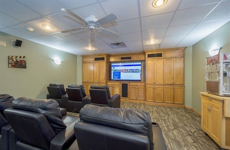 A cozy home theater room with recliner chairs and a large TV screen.
