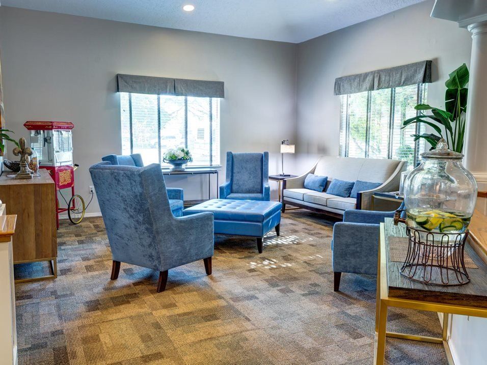 A cozy living room with blue furniture and large windows.