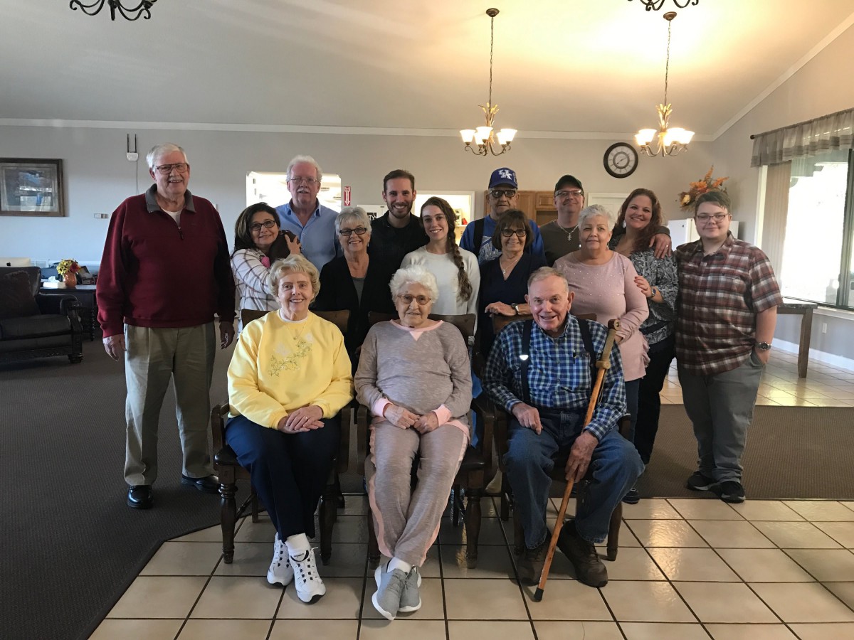 A group of people gathered together indoors for a family photo.