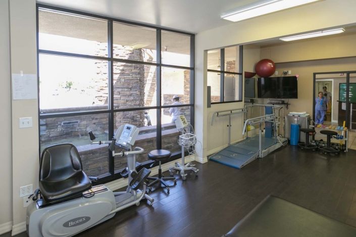 A well-equipped physical therapy room with various exercise machines and tools.