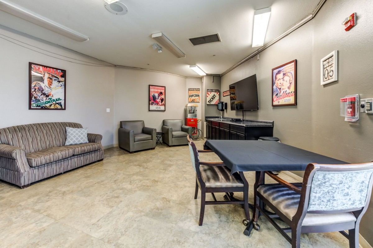 A cozy lounge area featuring comfortable seating, a table, and a television.