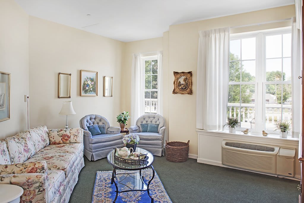 A cozy living room with comfortable seating, elegant decor, and a bright window view.