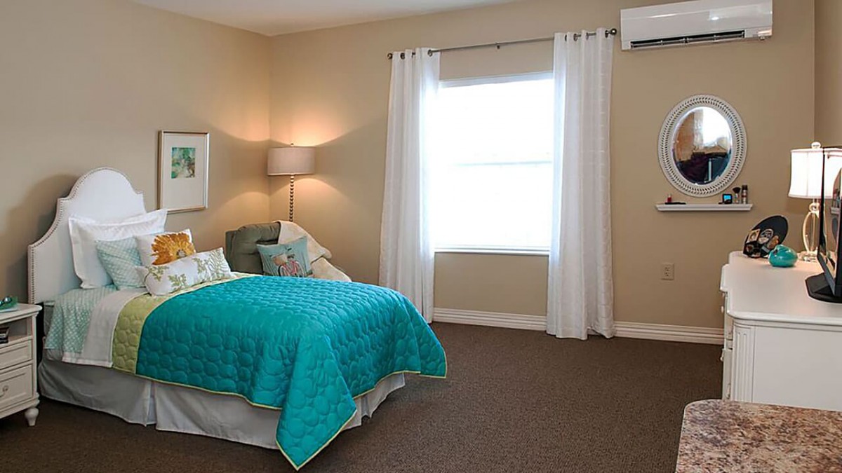 A cozy bedroom with a teal bedspread, white curtains, and modern decor.