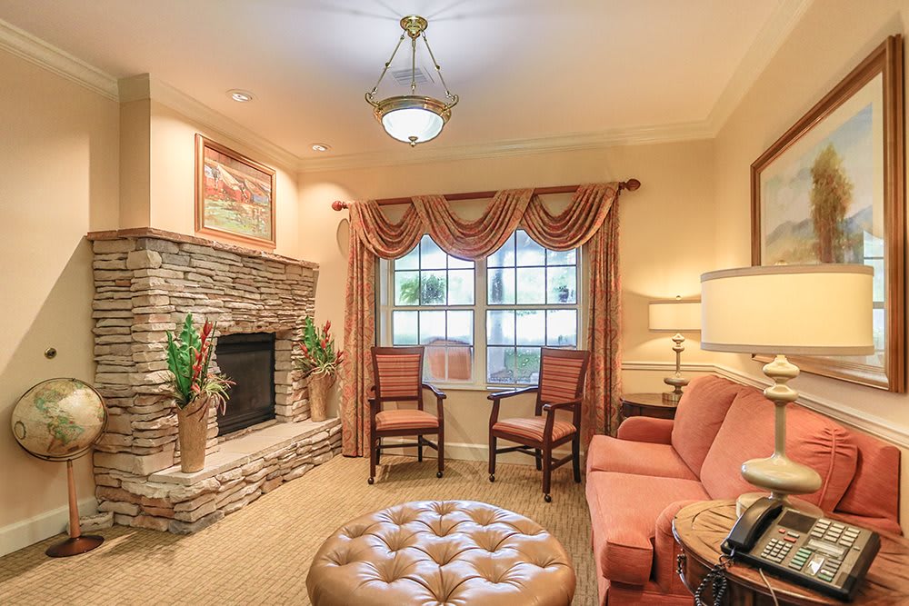 A cozy living room with a stone fireplace and elegant furnishings.
