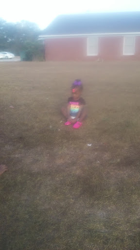 A child enjoying a playful moment outside in the grass.