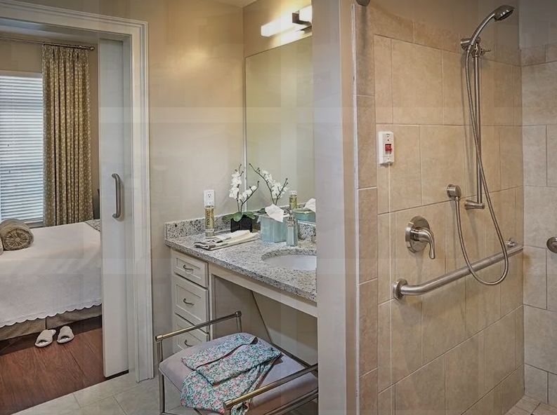 A modern bathroom featuring a sink with a mirror, a walk-in shower, and neatly organized towels.