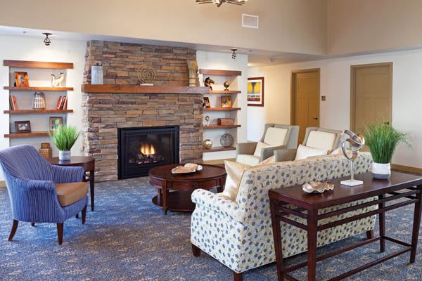 A cozy living room with a stone fireplace and comfortable seating.