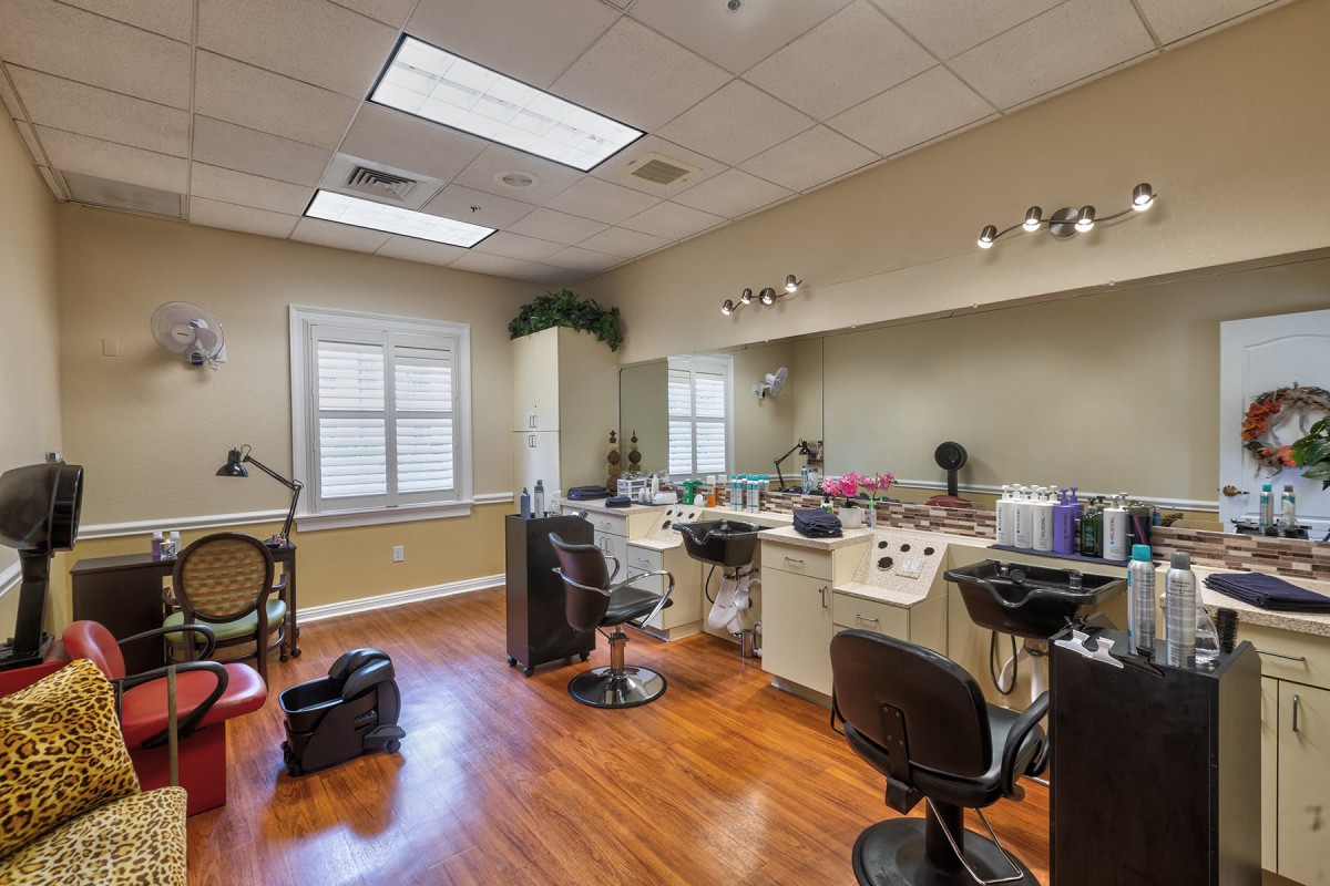 A well-lit hair salon with multiple styling stations and barber chairs.