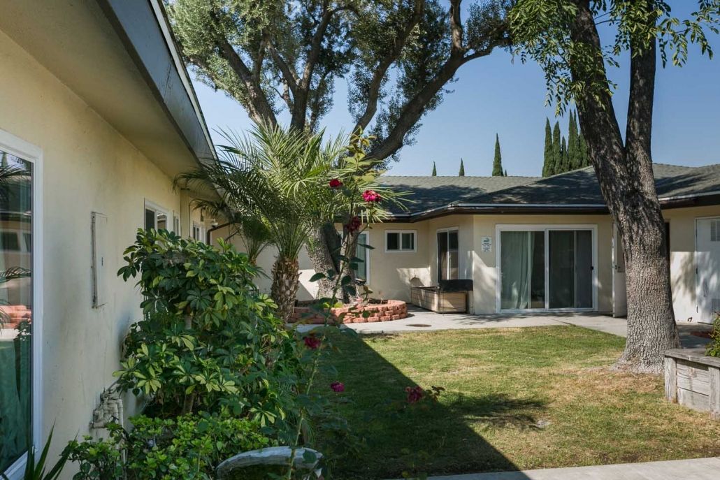 A backyard view of a house with a garden and patio area.