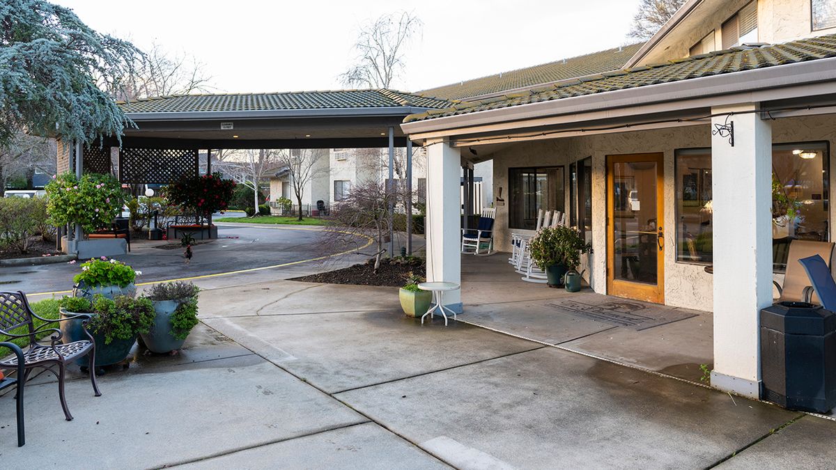 A driveway leading to the entrance of a building with a covered walkway.