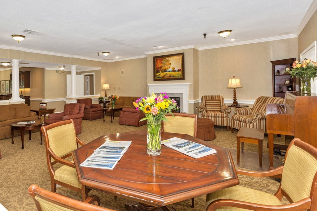 A cozy living room with comfortable seating and a table adorned with fresh flowers.