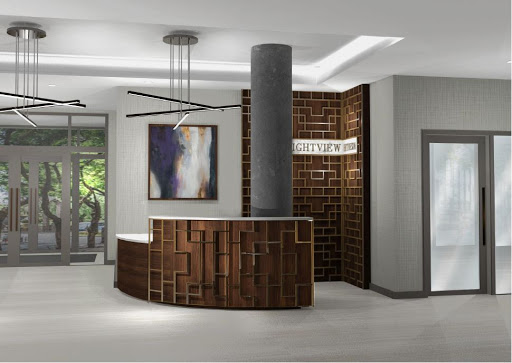 A stylish reception area featuring a curved wooden desk, modern lighting, and decorative artwork.