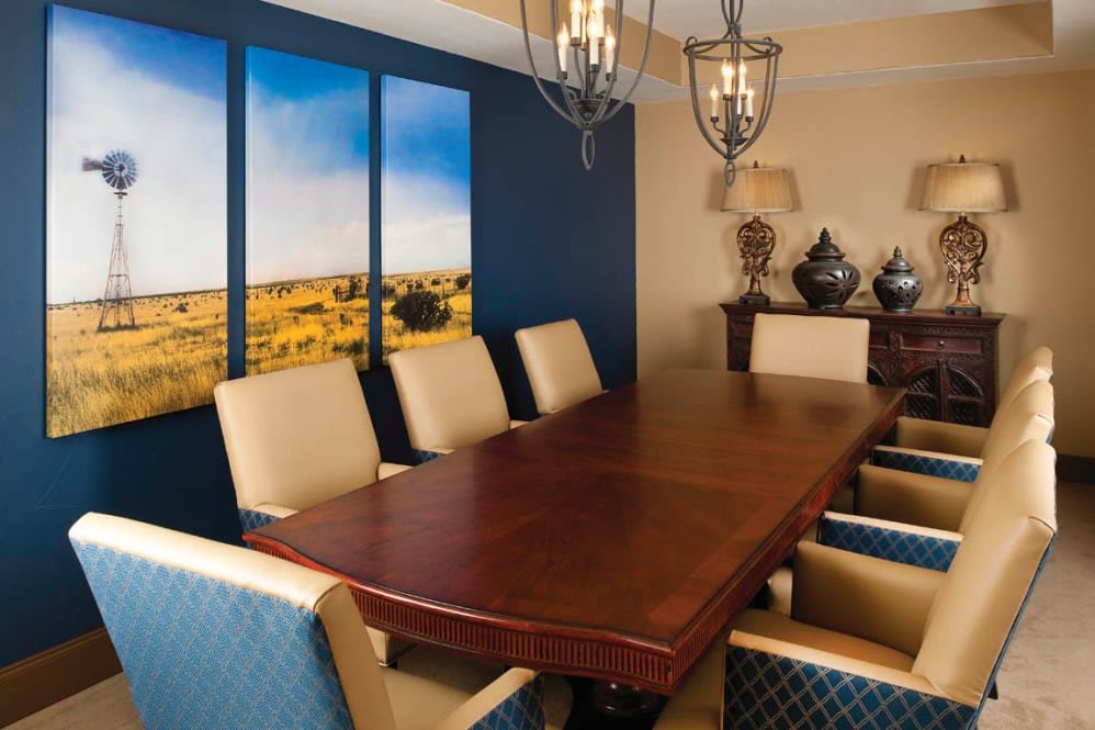 A stylish dining room with a wooden table, upholstered chairs, and decorative wall art.