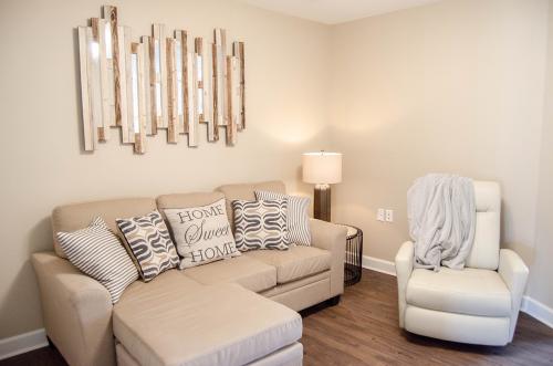 A stylish and cozy living room featuring a comfortable sectional sofa with decorative pillows, complemented by modern wall art and warm lighting.