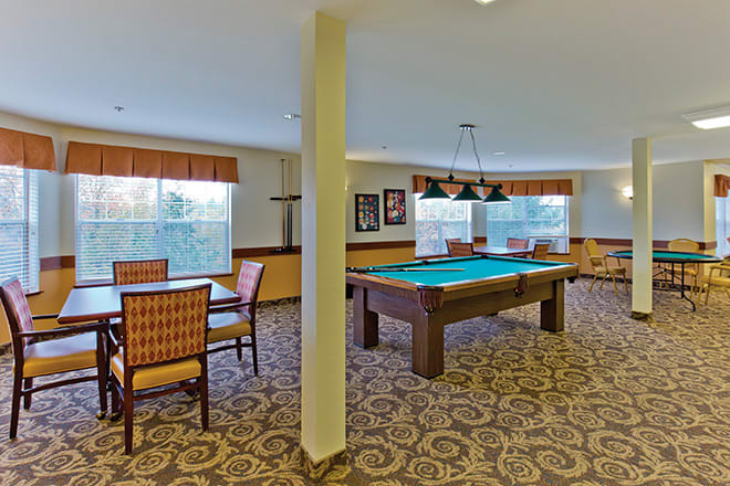 A cozy game room featuring a pool table and seating areas.