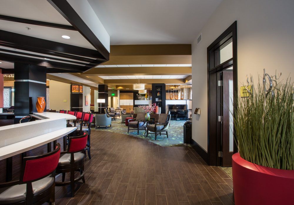 A modern hotel lobby featuring a stylish seating area with contemporary furniture and lighting.