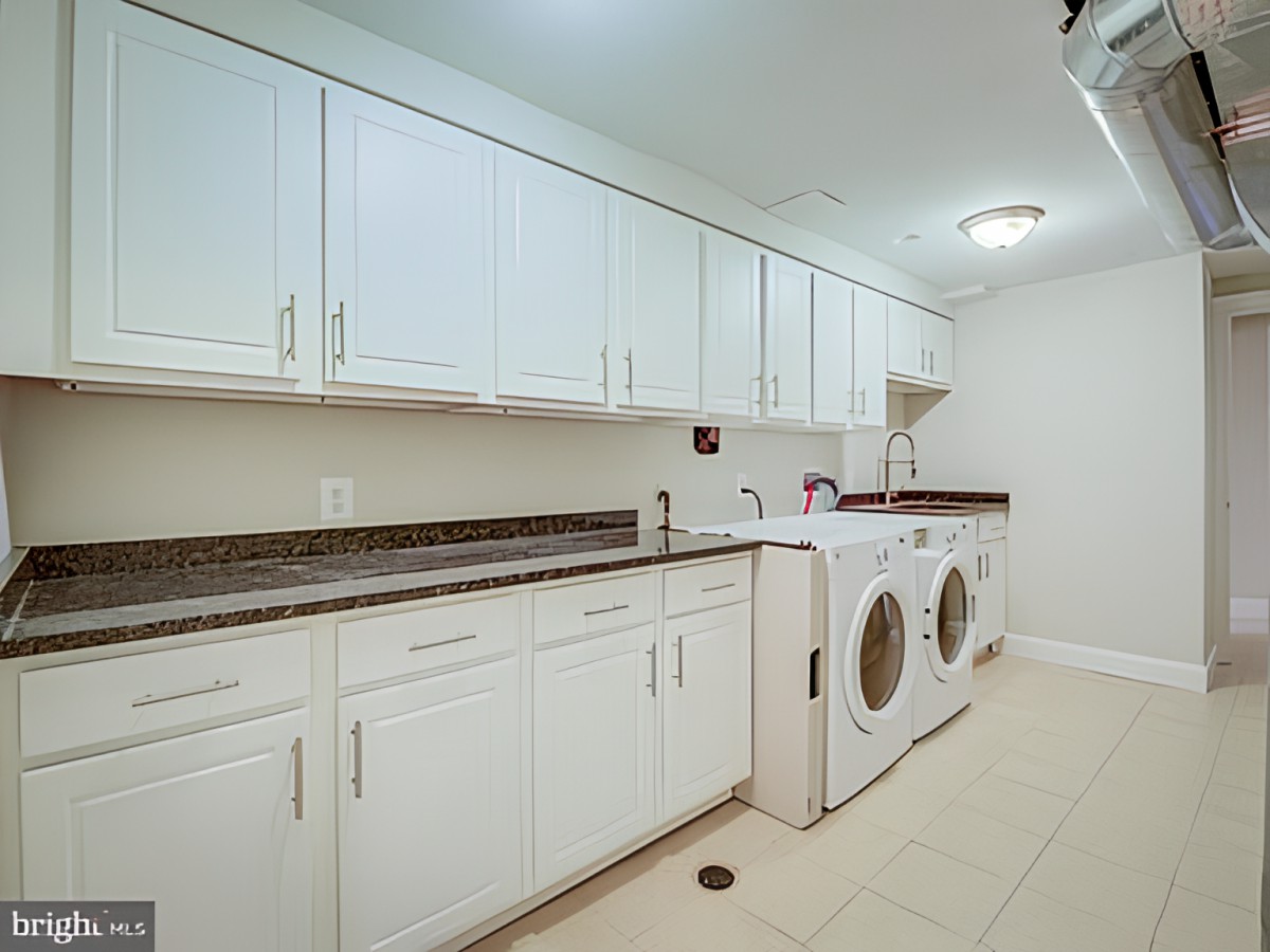 A spacious laundry room with ample storage and modern appliances.