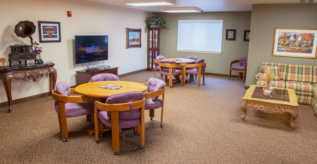 A cozy living room with multiple seating areas and a television.
