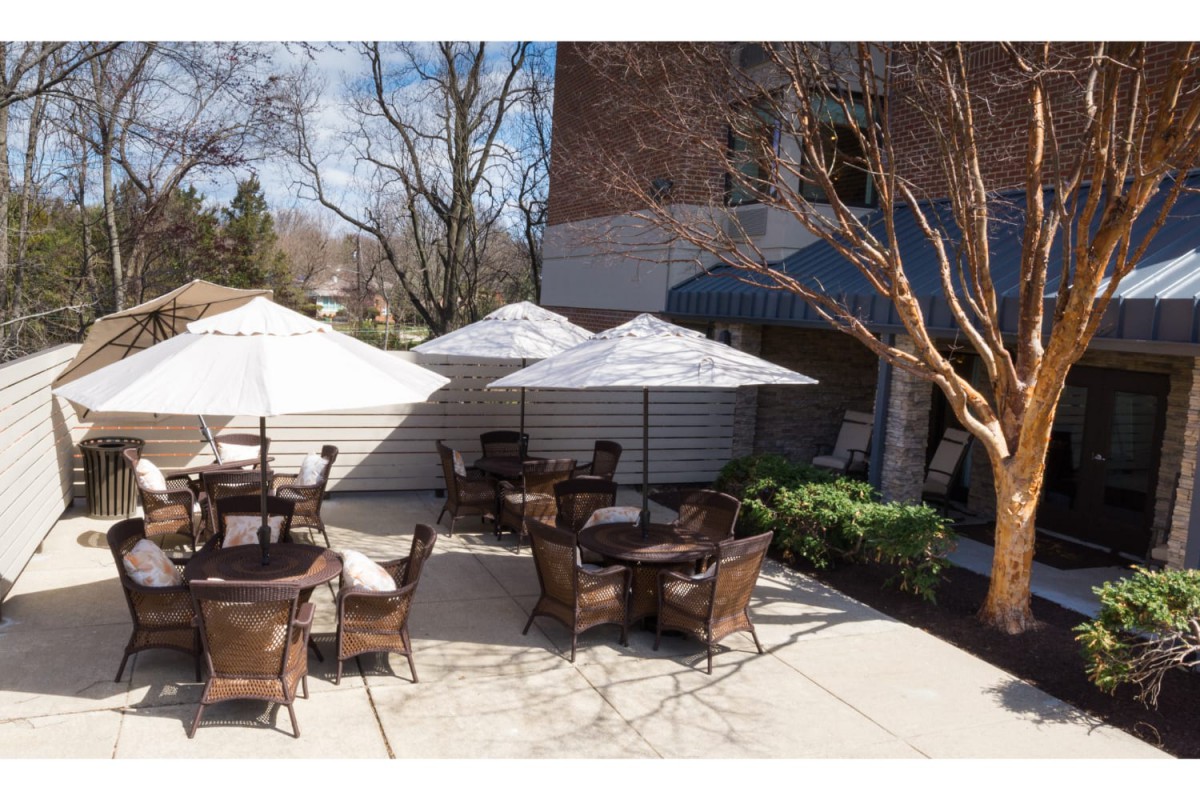 Outdoor patio area with tables, chairs, and umbrellas on a sunny day.