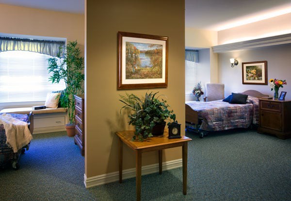 A cozy, well-decorated interior space featuring a bed, plants, and wall art, suggesting a welcoming, home-like environment.