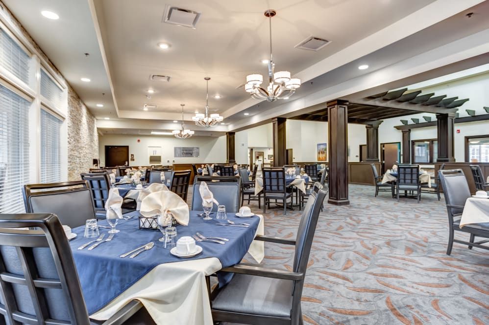 An elegantly set indoor dining area with tables and chairs.