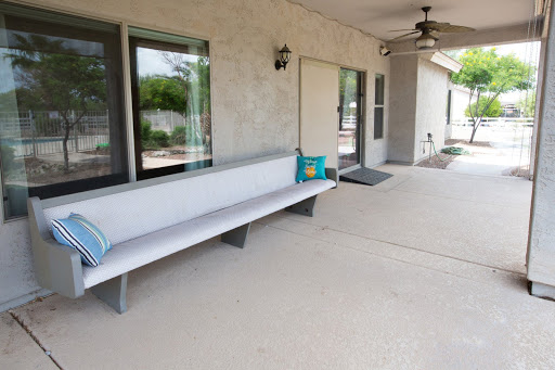 A modern outdoor patio area featuring a sleek bench and ceiling fan, perfect for relaxation.