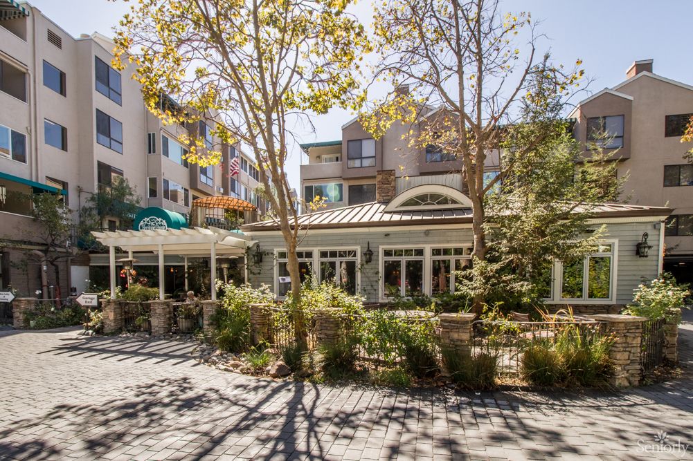 A residential building surrounded by trees on a sunny day.