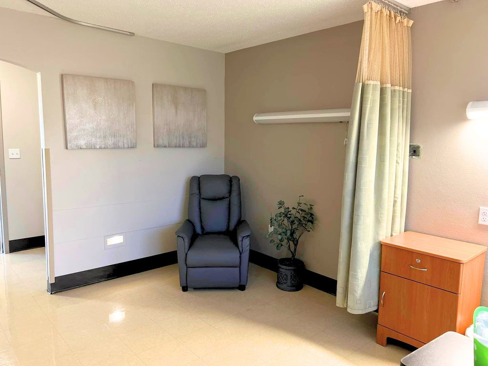 A hospital room with a comfortable chair and minimalist decor.