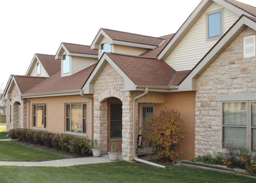 A suburban house with a brick exterior and well-maintained lawn.