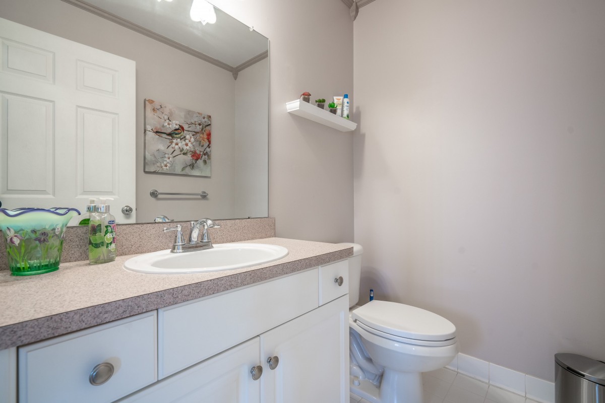 A minimalist bathroom with a sink, mirror, and toilet.