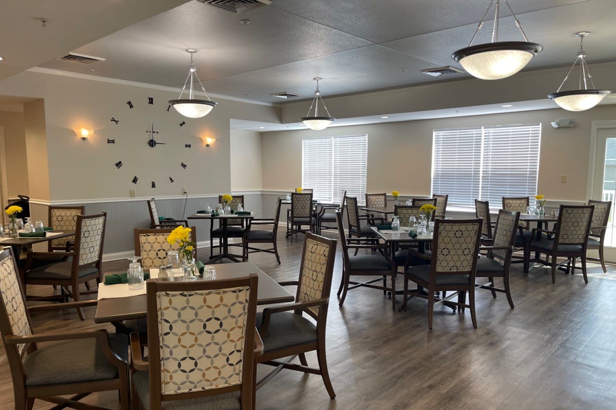 A well-lit dining area with neatly arranged tables and chairs.