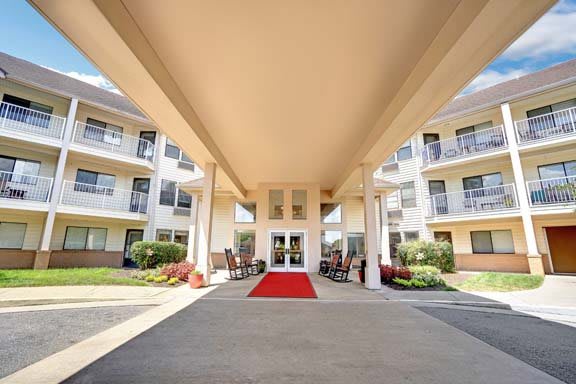 Entrance of a building featuring a red carpet and landscaped surroundings.