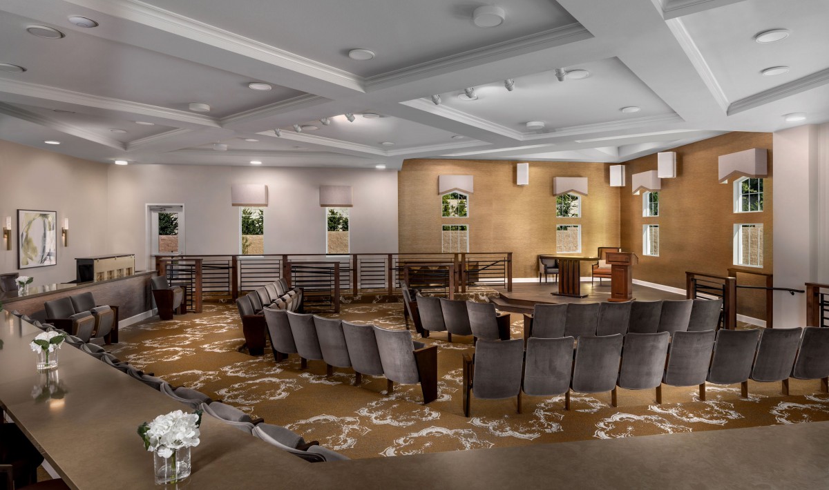 A modern, empty conference room with arranged seating and ceiling lighting.