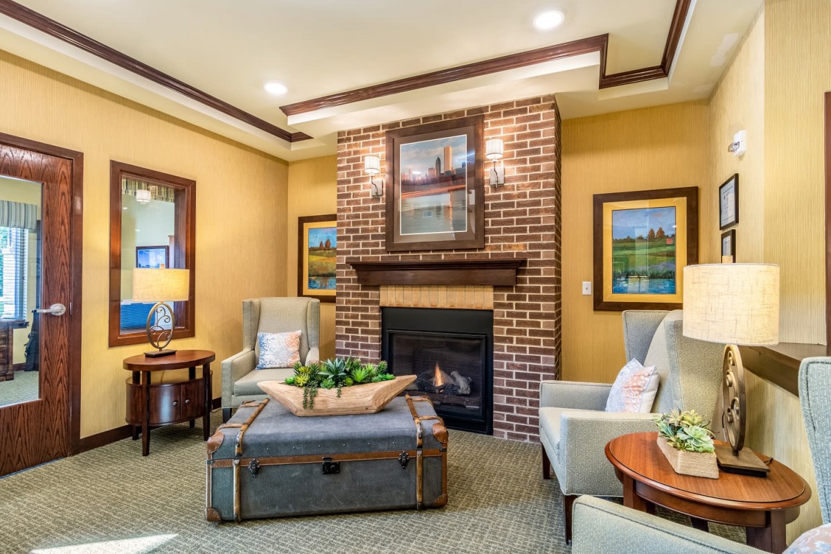 A cozy living room with a warm fireplace, elegant furniture, and tasteful artwork.