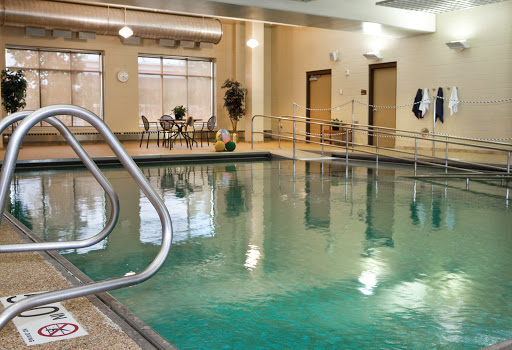 A serene indoor pool area featuring clear water and comfortable seating.