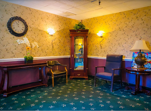 A cozy seating area featuring elegant furniture, decorative wallpaper, and warm lighting.
