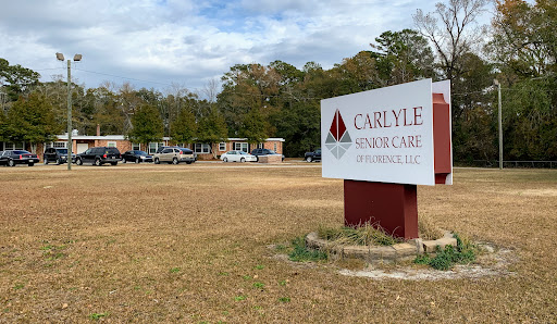 A view of the Carlyle healthcare facility with a prominent sign in the foreground.