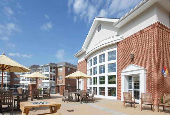 A sunny day view of a residential apartment building with an outdoor patio area.