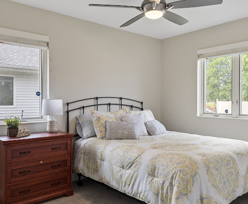 A cozy and inviting bedroom featuring a comfortable bed, stylish nightstand, and ample natural light.