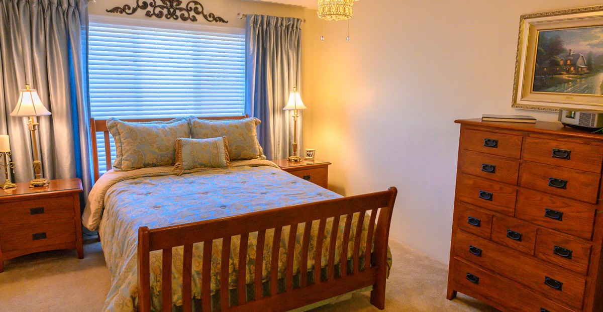 A cozy bedroom with wooden furniture and soft lighting.